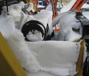 The engine bay of the frontend loader full of snow