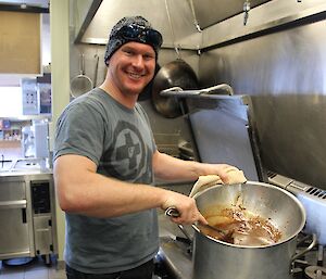 Rich mixing up a his mars bar and coffee syrup in a pot over the kitchen stove