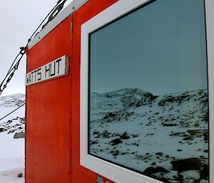 A close up shot of the hut window with the reflection of the surrounding scenery