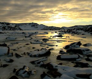 Large rocks protruding from a frozen fresh water stream