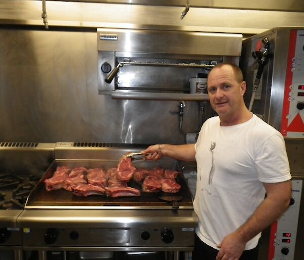 Rodney the chef standing in front of the hot plate cooking the steak for dinner