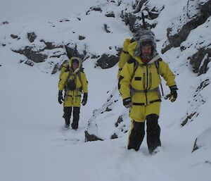Two expeditioners walking cross county in the snow caring their survival packs