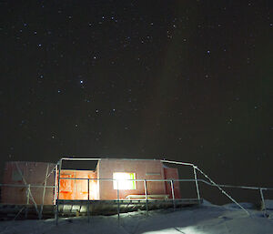 Brookes hut at night under a faint aurora