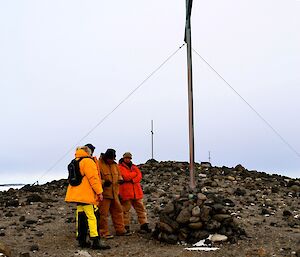 Three expeditioners standing next to one of the three crosses on the Island