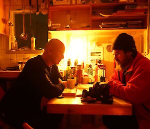 Gavin and Mark sitting at the table by candle light