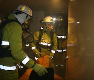 Three expeditioners retrieve a dummy casualty