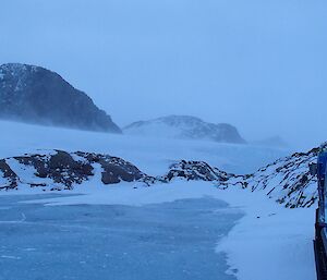 Wind blowing snow off the Plato with a frozen lake in the foreground