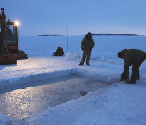 Final adjustments to open the ice hole for the swim