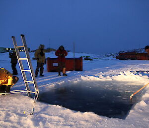 The ice hole with ladder setup and the surface cleared of ice for the swim