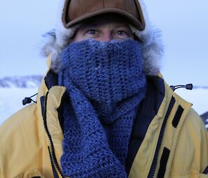 Man wearing hat and big scarf to keep his face warm.