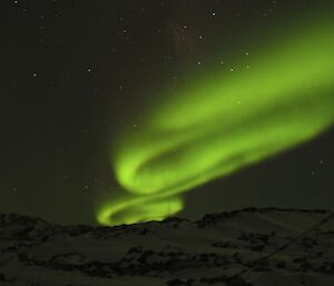 A magnificent colourful Aurora with a bright green sweep in the sky above Watts hut