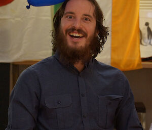 Seated expeditioner with balloon sticking to his hair because of static electricity