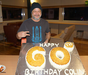 Expeditioner holding up board with 60th birthday cake