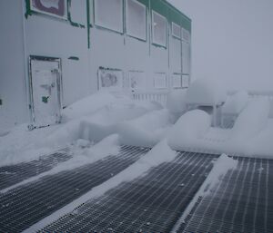 Snow builds up due to the blizzard on the outdoor setting that is bolted to the front deck