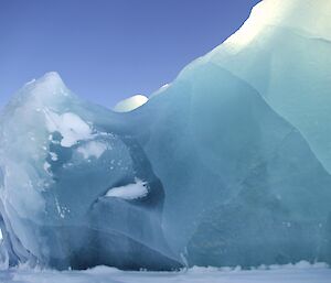 The sun brings out the beauty of the ice bergs stuck fast for the winter in the frozen sea ice