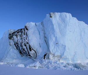 The sun brings out the beauty of the ice bergs stuck fast for the winter in the frozen sea ice