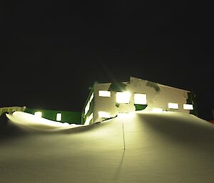 The internal lights of the Living Quarters shining bright against the night sky from the bottom of the massive blizz tail on the southern end of the building