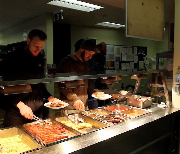 Expeditioners line up for a hearty cooked breakfast before heading out into the cold to film