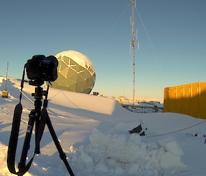 Picture of a camera filming an expeditioner climbing the communications tower near Operations building and ANARESAT radome