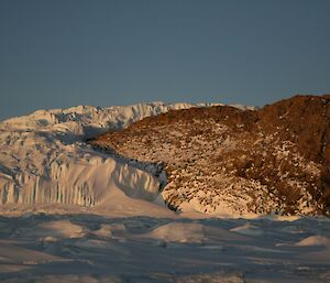 The glacier has wrapped itself around a small land mass as it slowly makes it way to the coast