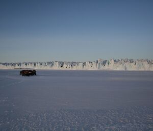 Four quad bikes on the sea ice with the majestic Sørsdal Glacier in the background