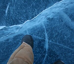 Taking a photo of the frozen water with my winter boots in the picture