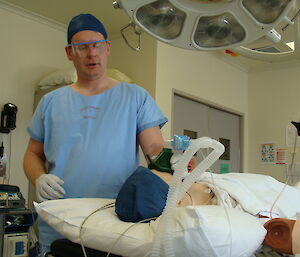 An expeditioner during training at the Hobart hospital applying oxygen to the dummy patient