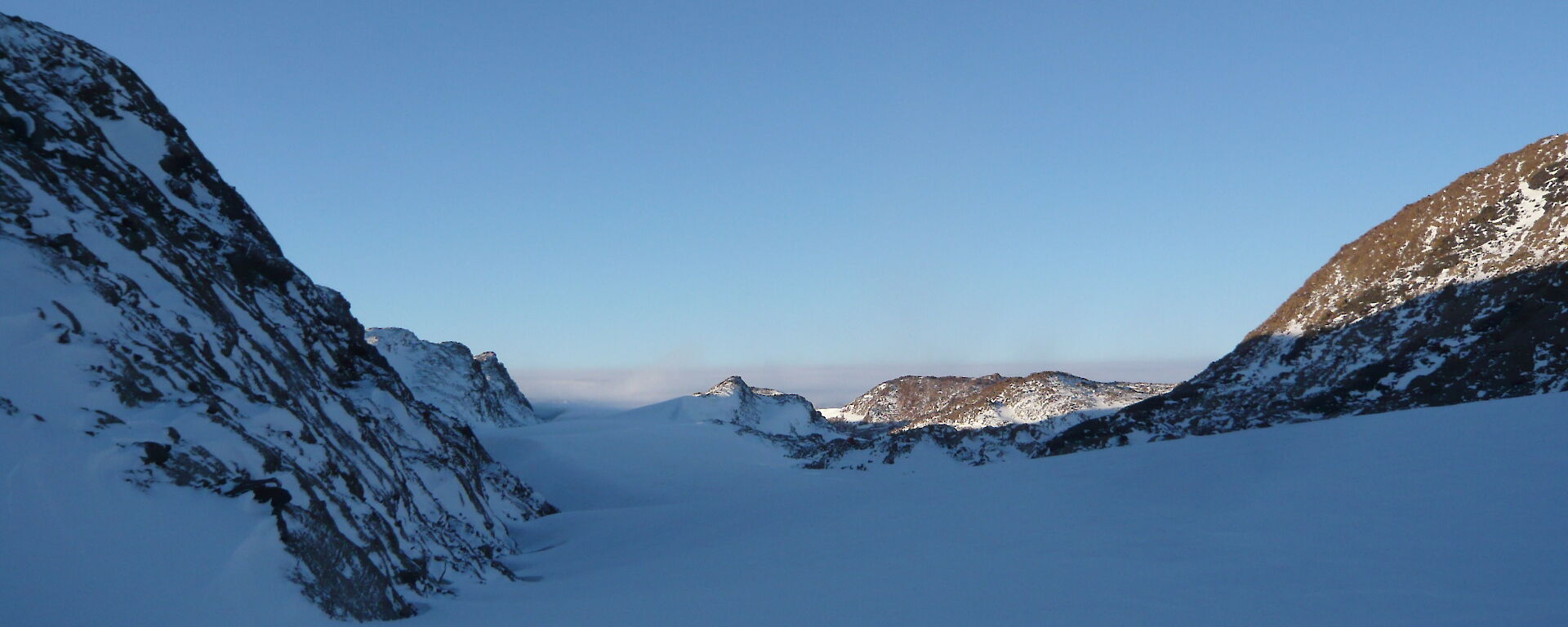 Looking up to the plateau along the snow drift within the valley with the Melon just of centre to the right
