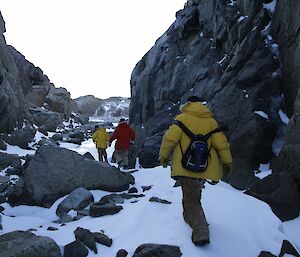Expeditioners walking between rock walls of Grimmia Gorge