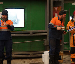 Two expeditioners prepare to launch their aircraft while a third offers advice