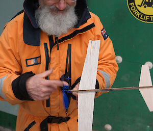 Doc winding the propeller of balsa aircraft