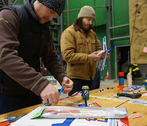 Richard and Simon at table preparing balsa aircraft