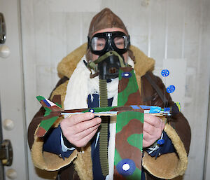 Gavin in WW2 pilot attire holding painted aircraft