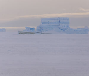 Large iceberg showing bands of blue and white ice
