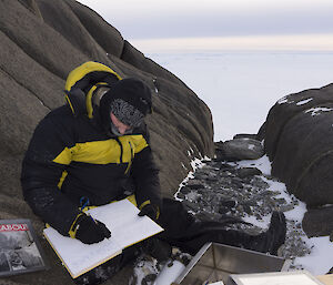 Richard seated making entry into log book