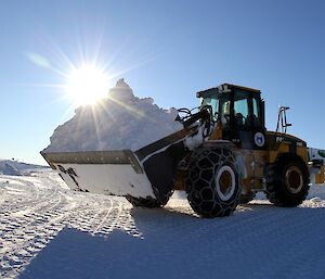 One of the station loaders moving snow away from the buildings