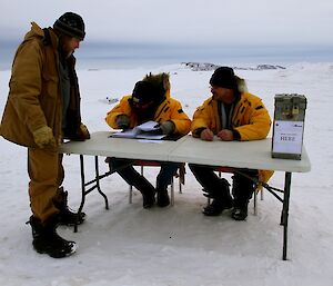 Official electoral offices marking off expeditioners names before voting