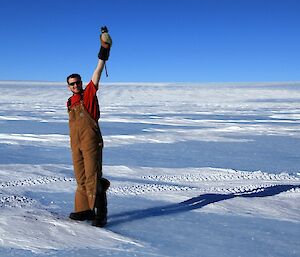 Expeditioner taking a wind strength reading at the Plato on a magnificently clear blue skied day