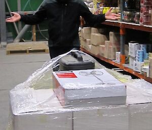 Expeditioner looking at a pallet of boxes in the green Store gesturing “were do I start”