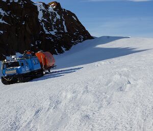 The red and blue Hägglunds descending the south snow ramp from the Plateau onto the sea ice