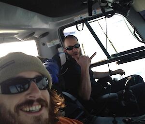 Two expeditioners in a Prinoth snow groomer working on a ski landing area