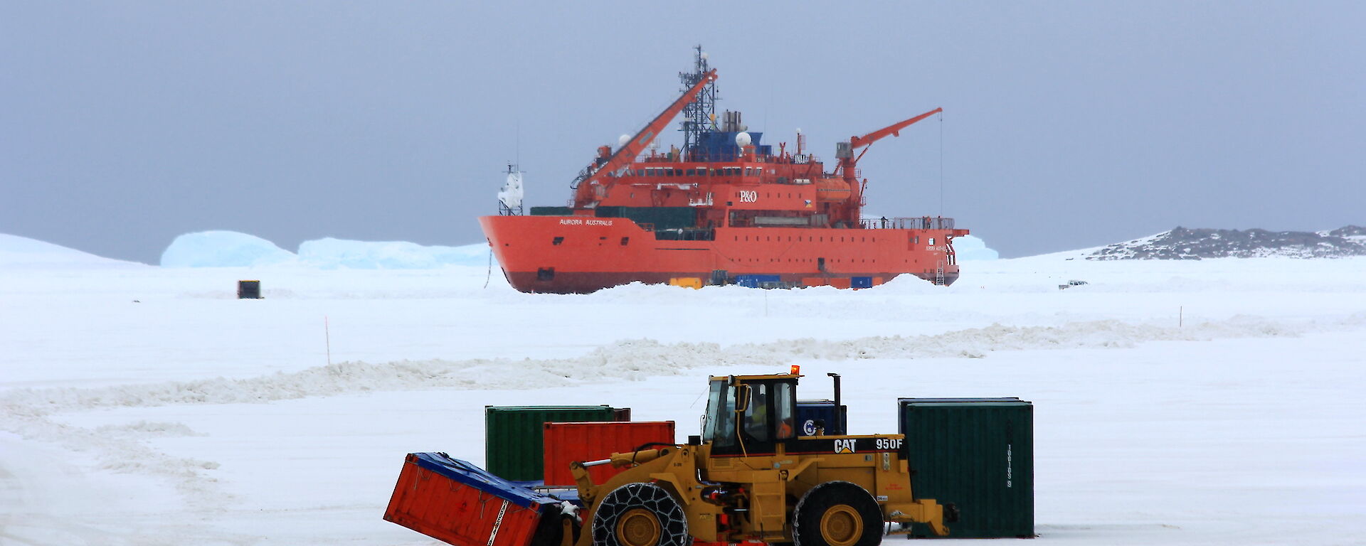 Heavy machinary awaiting on the ice near the ship