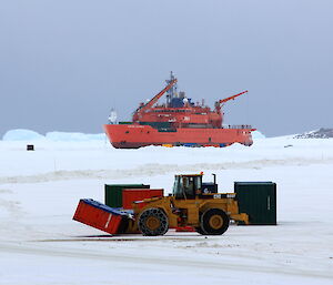 Heavy machinary awaiting on the ice near the ship