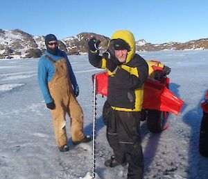 Two expeditioners drilling the ice for depth