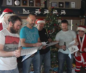 A group of plumbers singing in front of the Christmas tree