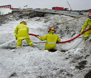 Expeditioners on a fire hose in the snow