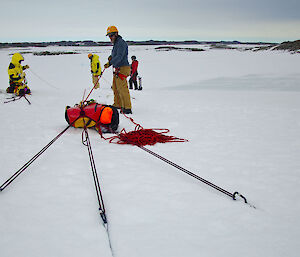 Ropes being affixed to ice for a stretcher rescue