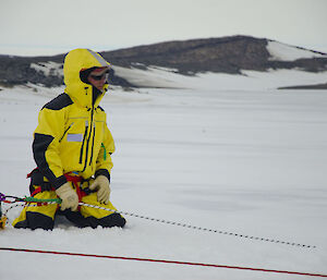 An expeditioner with a rope to pull the stretcher