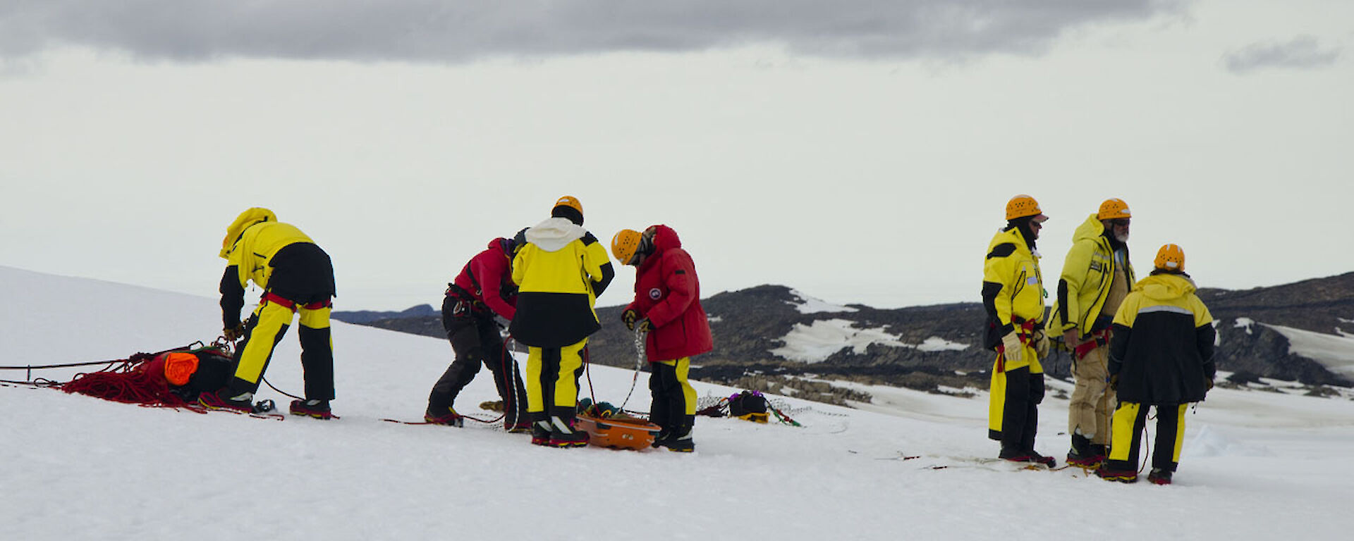 Group of expeditioners with a stretcher on the ice