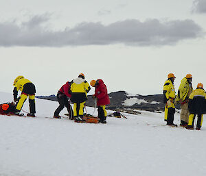 Group of expeditioners with a stretcher on the ice